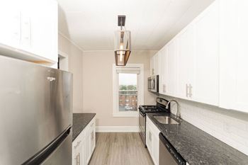 a kitchen with granite counter tops and stainless steel appliances at The Packard, West Hartford, CT